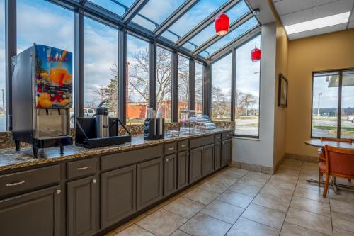 a large kitchen with a counter with windows at Days Inn by Wyndham Perrysburg Toledo in Perrysburg