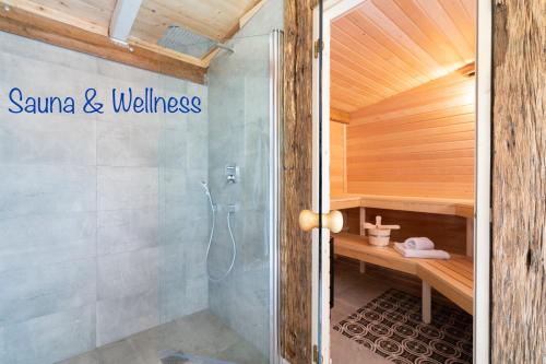 Baño con sauna y letrero de bienestar en la pared en FeWo STRANDGUT- Familien - Hunde - strandnah - eigene Terrasse - Sauna & Wellness, en Sierksdorf