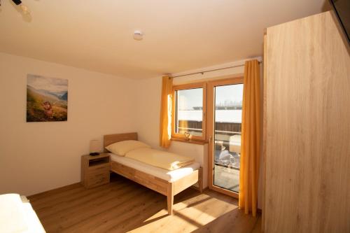 - une petite chambre avec un lit et une fenêtre dans l'établissement Apart Christof, à Schwendau