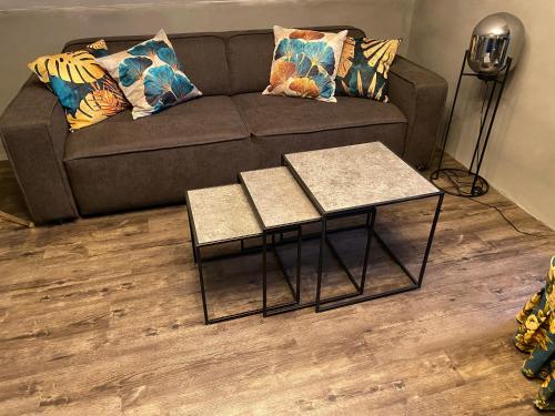 a living room with a couch and two tables at W-8 - Moderne Ferienwohnung mit viel Charme & spektakulärem Blick in Sandebeck