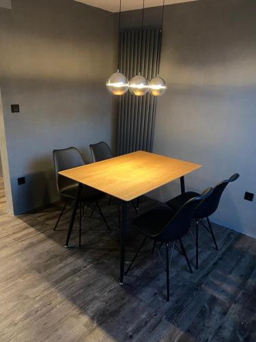 una mesa de madera y sillas en una habitación en W-8 - Moderne Ferienwohnung mit viel Charme & spektakulärem Blick en Sandebeck