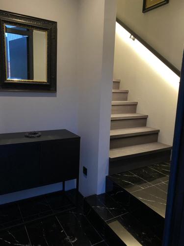 a bathroom with a staircase with a mirror and a sink at W-8 - Moderne Ferienwohnung mit viel Charme & spektakulärem Blick in Sandebeck
