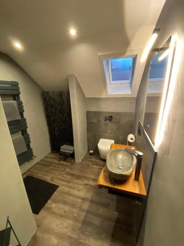 a bathroom with a sink and a toilet at W-8 - Moderne Ferienwohnung mit viel Charme & spektakulärem Blick in Sandebeck