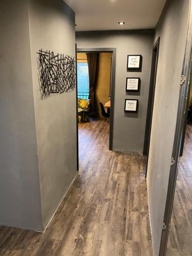 a hallway with wooden floors and a wall with art on it at W-8 - Moderne Ferienwohnung mit viel Charme & spektakulärem Blick in Sandebeck