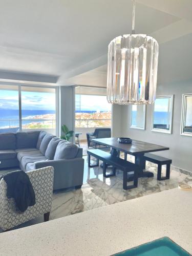 a living room with a blue couch and a table at Beachfront Condo close Puerto Nuevo, Papas, and Valle de Guadalupe in Rosarito