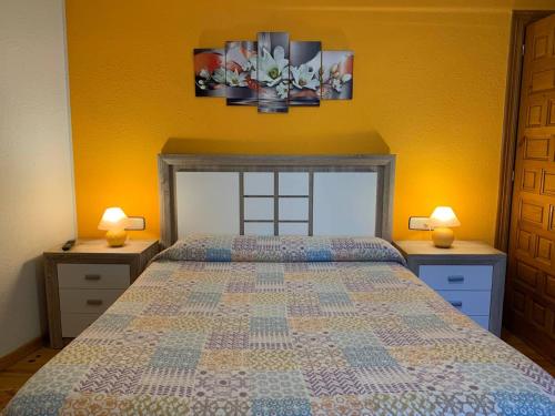a bedroom with a bed with two night stands and two lamps at Apartamento Rural Lago Enol in Cangas de Onís