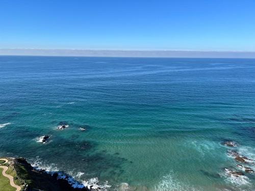 an aerial view of the ocean with people in the water at Beachfront Condo close Puerto Nuevo, Papas, and Valle de Guadalupe in Rosarito