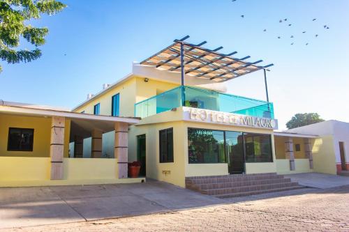 a yellow building with a sign on top of it at Hotel EL MILAGRO in El Fuerte