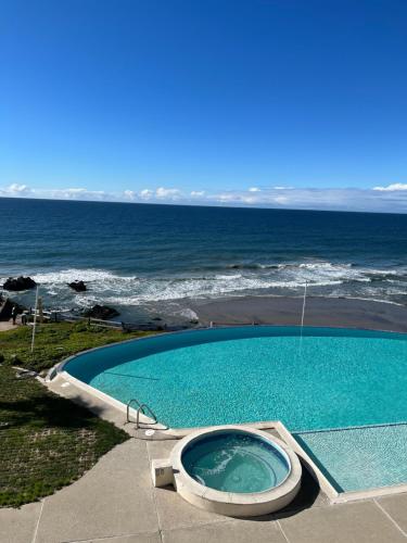 a swimming pool with a toilet next to the ocean at Beachfront Condo close Puerto Nuevo, Papas, and Valle de Guadalupe in Rosarito