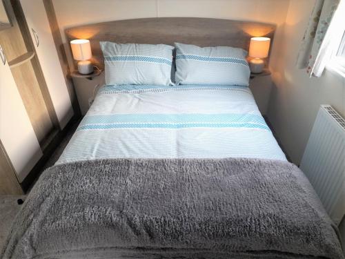a bed in a small room with two pillows at 3 Bedroom Modern Caravan Sleeps up to 8 in Millom