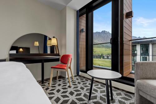 a hotel room with a bed and a desk and a chair at Holiday Inn Queenstown Remarkables Park in Queenstown