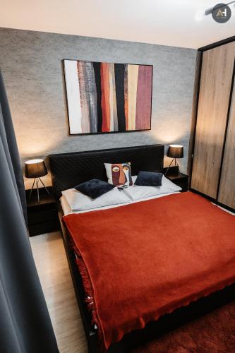 a bedroom with a bed with a red blanket at AH Mlynská Bašta II in Košice