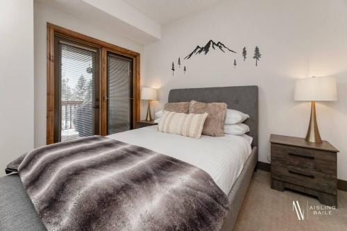 ein Schlafzimmer mit großem Bett und Fenster in der Unterkunft Heavenly Mountain Hideaway, Pool, Hot Tub in Radium Hot Springs