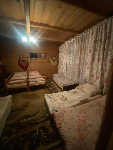a room with three beds in it with a light on at Góralskie Pokoje in Witów