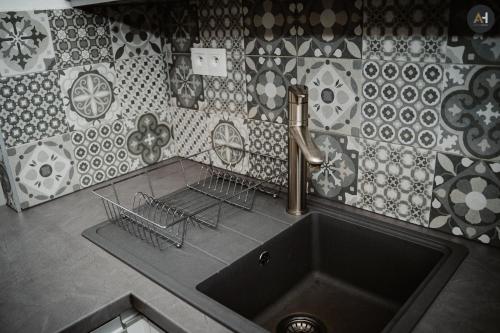 a kitchen with a sink and a tiled wall at AH Poštová in Košice