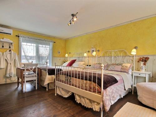 a bedroom with a bed and yellow walls at Le Gite Du Hu-Art in Quebec City