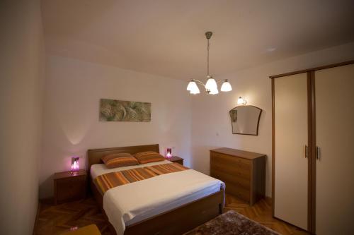 a bedroom with a bed and a cabinet and lights at House Maca in Palit