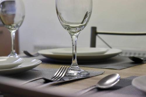 a table with a wine glass and plates and silverware at Entire Family Vacation Home . WiFi . FREE Parking in Beeston