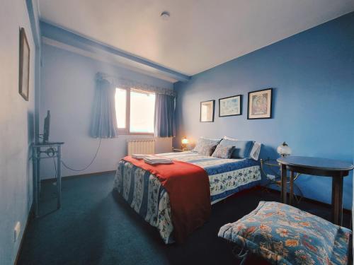 a bedroom with two beds and a table and a window at FLOR AUSTRAL in Ushuaia