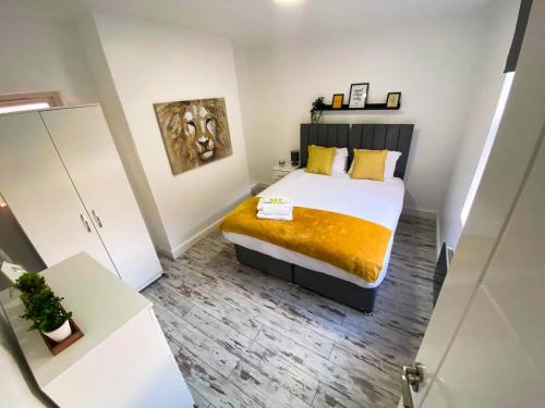 Dormitorio pequeño con cama con manta amarilla en Beautiful Apartment - up to 4 guests - Leicester City Centre . Free WIFI, en Leicester