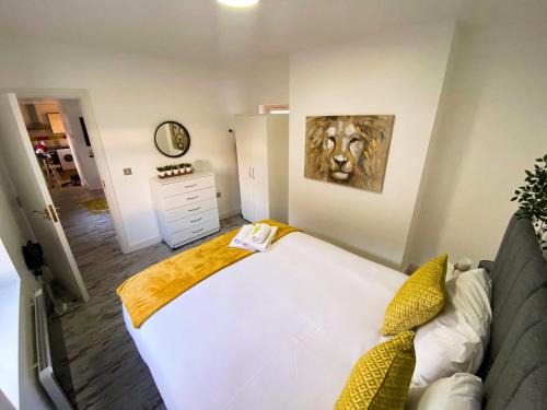 Un dormitorio con una cama blanca y una pintura en la pared en Beautiful Apartment - up to 4 guests - Leicester City Centre . Free WIFI, en Leicester