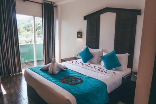 a bedroom with a large bed with a large window at Sunshine Resort & Spa Sigiriya in Sigiriya
