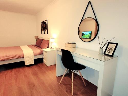a bedroom with a bed and a desk with a mirror at Rose Garden House in Bucharest