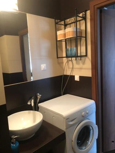een badkamer met een wasmachine en een wastafel bij Apartament Elbląg Wyczółkowskiego 10 in Elblag