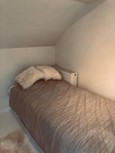 a bedroom with a bed with furry pillows on it at Le mazot d’Edouard et Celestin in Profondeville