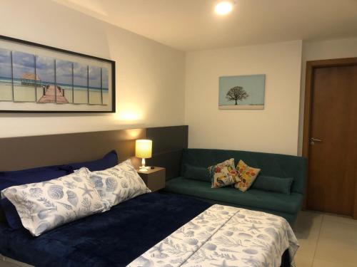 ein Schlafzimmer mit einem Bett und einem Sofa in der Unterkunft Apartamento Praia Grande in Arraial do Cabo