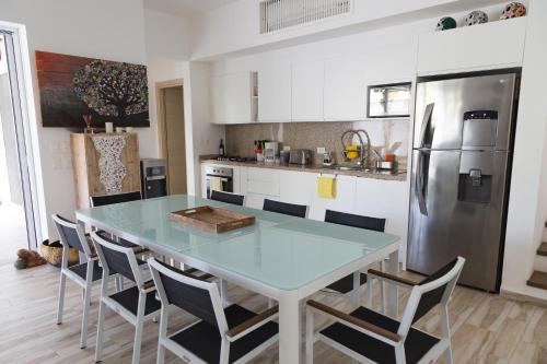 a kitchen with a table with chairs and a refrigerator at Luxury Private Villas , Private Pool, Private garden, Jacuzzi, 24hours security in Tulum