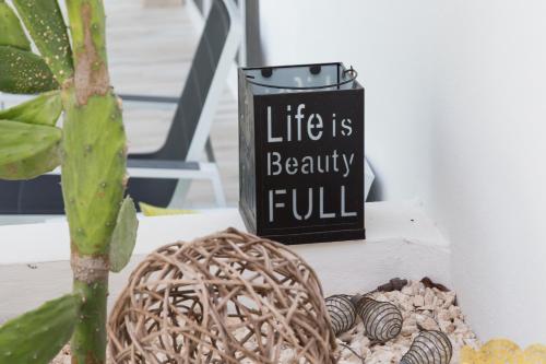a sign that says life is beautyful next to a plant at Luxury Private Villas , Private Pool, Private garden, Jacuzzi, 24hours security in Tulum