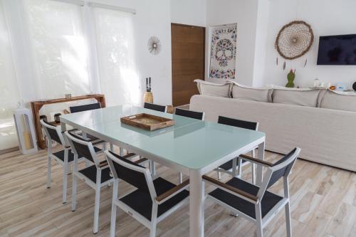a dining room with a glass table and chairs at Luxury Private Villas , Private Pool, Private garden, Jacuzzi, 24hours security in Tulum