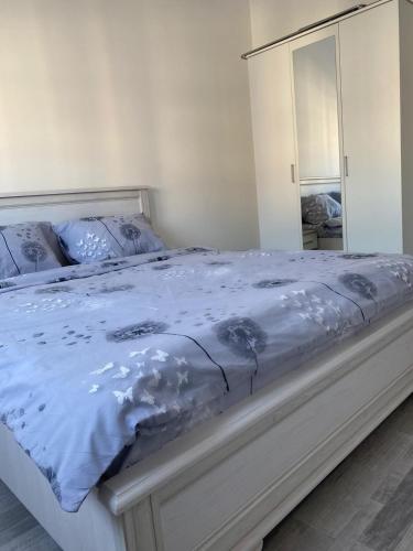 a bedroom with a bed with blue sheets and a mirror at Apartmani Milić Banja Koviljača in Banja Koviljača
