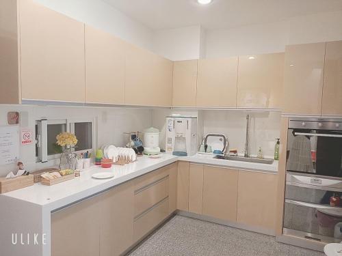 a large kitchen with white cabinets and a sink at Happy Life B&B in Donggang