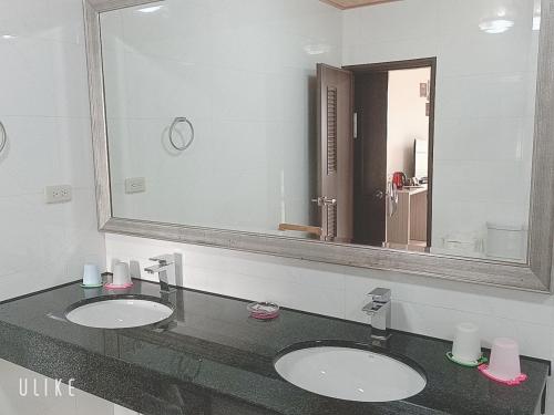 a bathroom with two sinks and a large mirror at Happy Life B&B in Donggang