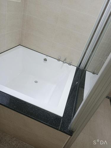 a bathtub in a bathroom with a white floor at Happy Life B&B in Donggang