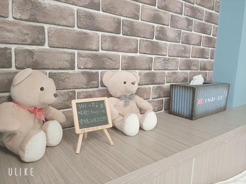 two teddy bears sitting on a shelf with a chalkboard at Happy Life B&B in Donggang