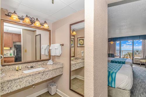 a hotel room with a bed and a bathroom at Holiday Pavilion 405 in Myrtle Beach