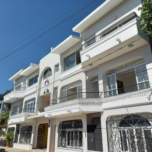 a white building with balconies on a street at Villas Frida Kahlo in Bucerías
