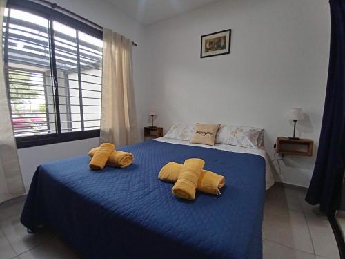 1 dormitorio con 2 toallas amarillas en una cama azul en Hermoso Departamento En Lujan De Cuyo Mendoza en Luján de Cuyo