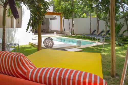 a patio with a yellow table and a pool at Luxury Private Villas , Private Pool, Private garden, Jacuzzi, 24hours security in Tulum