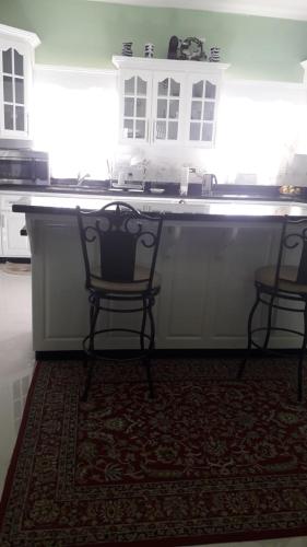 a kitchen with two chairs and a large counter top at LEO VILLA in Wallen