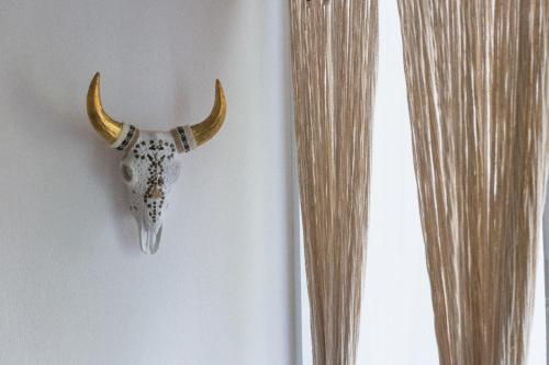 a skull of a bull with horns hanging on a wall at Luxury Private Villas , Private Pool, Private garden, Jacuzzi, 24hours security in Tulum