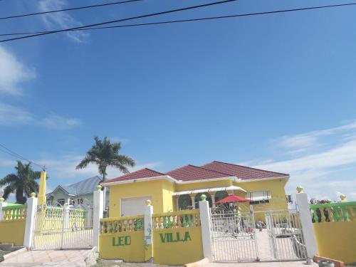 a yellow house with a white fence at LEO VILLA in Wallen