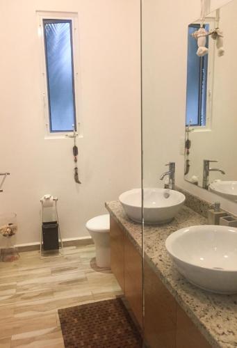 a bathroom with two sinks and a toilet at Luxury Private Villas , Private Pool, Private garden, Jacuzzi, 24hours security in Tulum