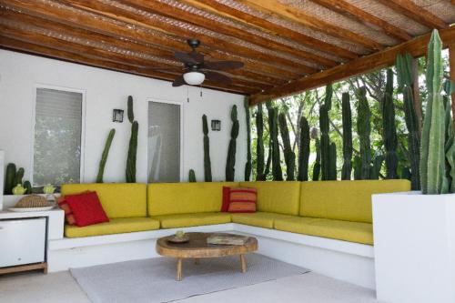 a living room with a yellow couch and a table at Luxury Private Villas , Private Pool, Private garden, Jacuzzi, 24hours security in Tulum