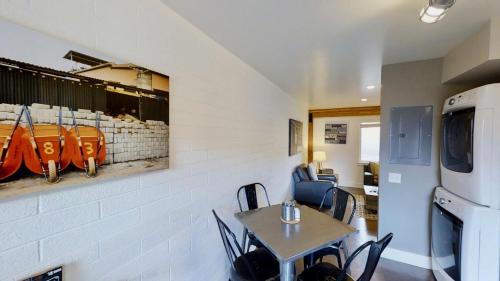 a dining room with a table and chairs and a refrigerator at Moab Flats #2 in Moab