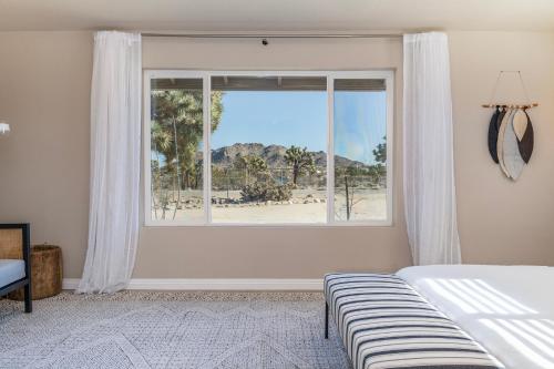 a bedroom with a window with a view of a beach at @Marbella Lane - Charming Tranquil Hideaway in Yucca Valley