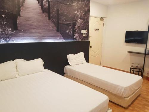 シンガポールにあるジ アメージング インのベッド2台とテレビが備わる客室です。